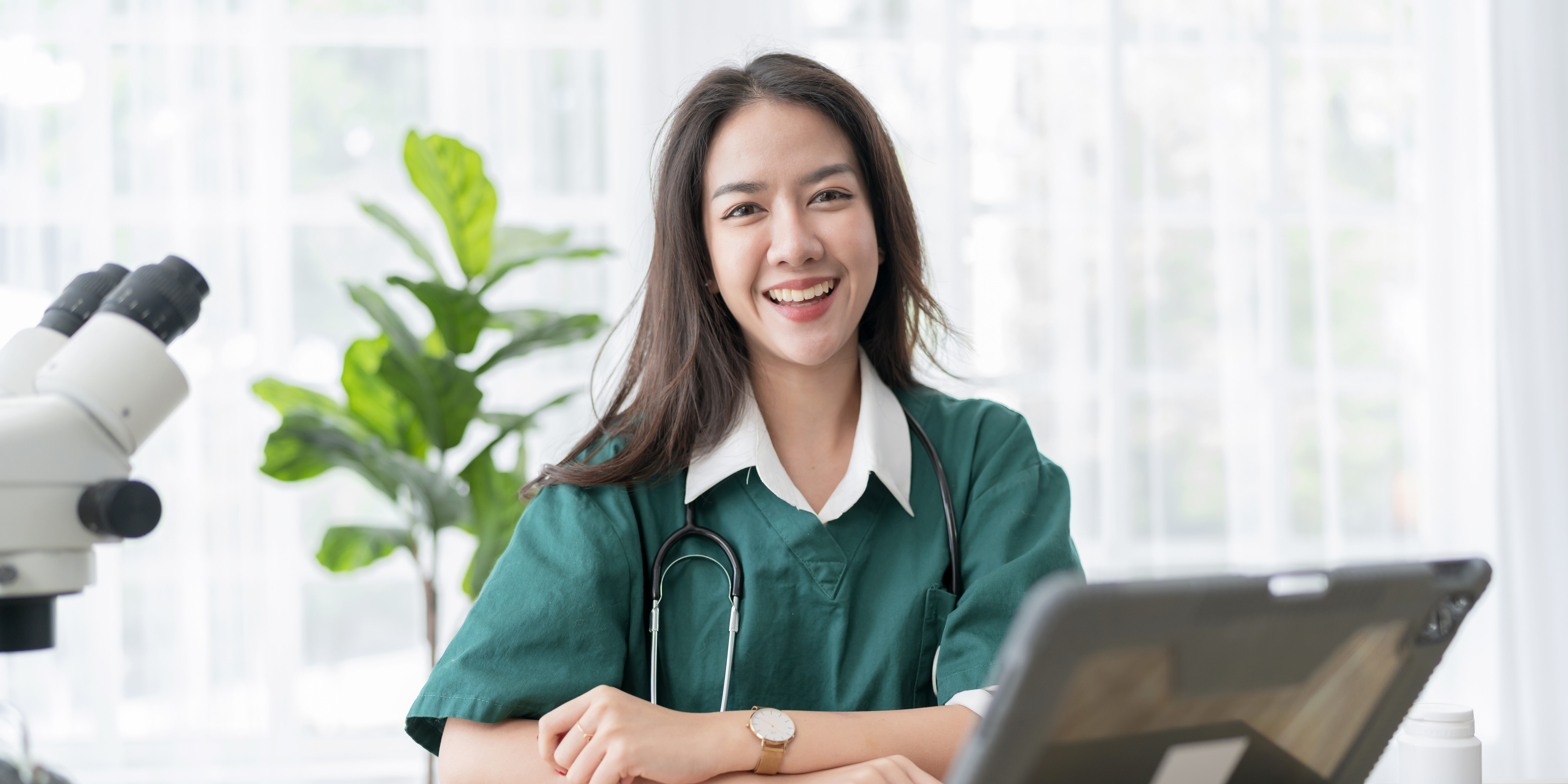 Young attractive Asian female doctor diagnosis talking and looking to camera in video conference ,Positive doctor waving and having online consultation on digital tablet laptop